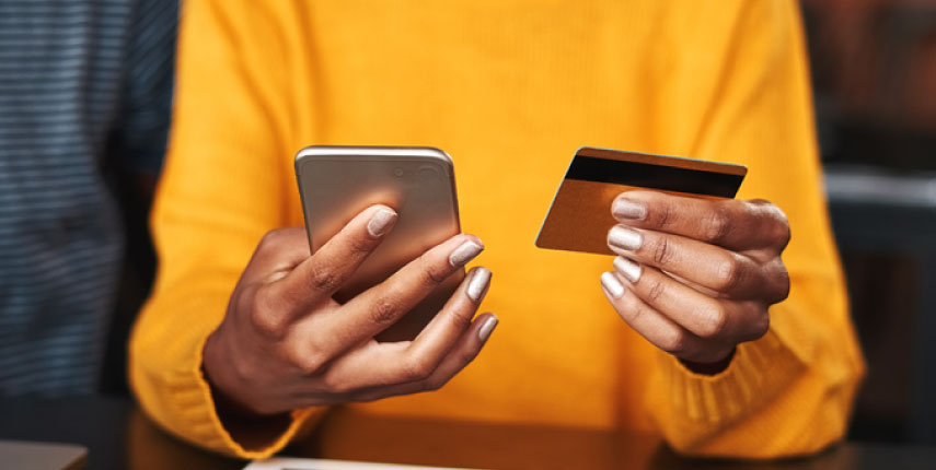 person holding phone and debit card